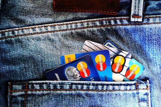Close-up of a denim pocket with multiple credit cards, illustrating finance and fashion. Close-up of a denim pocket with multiple credit cards, illustrating finance and fashion.